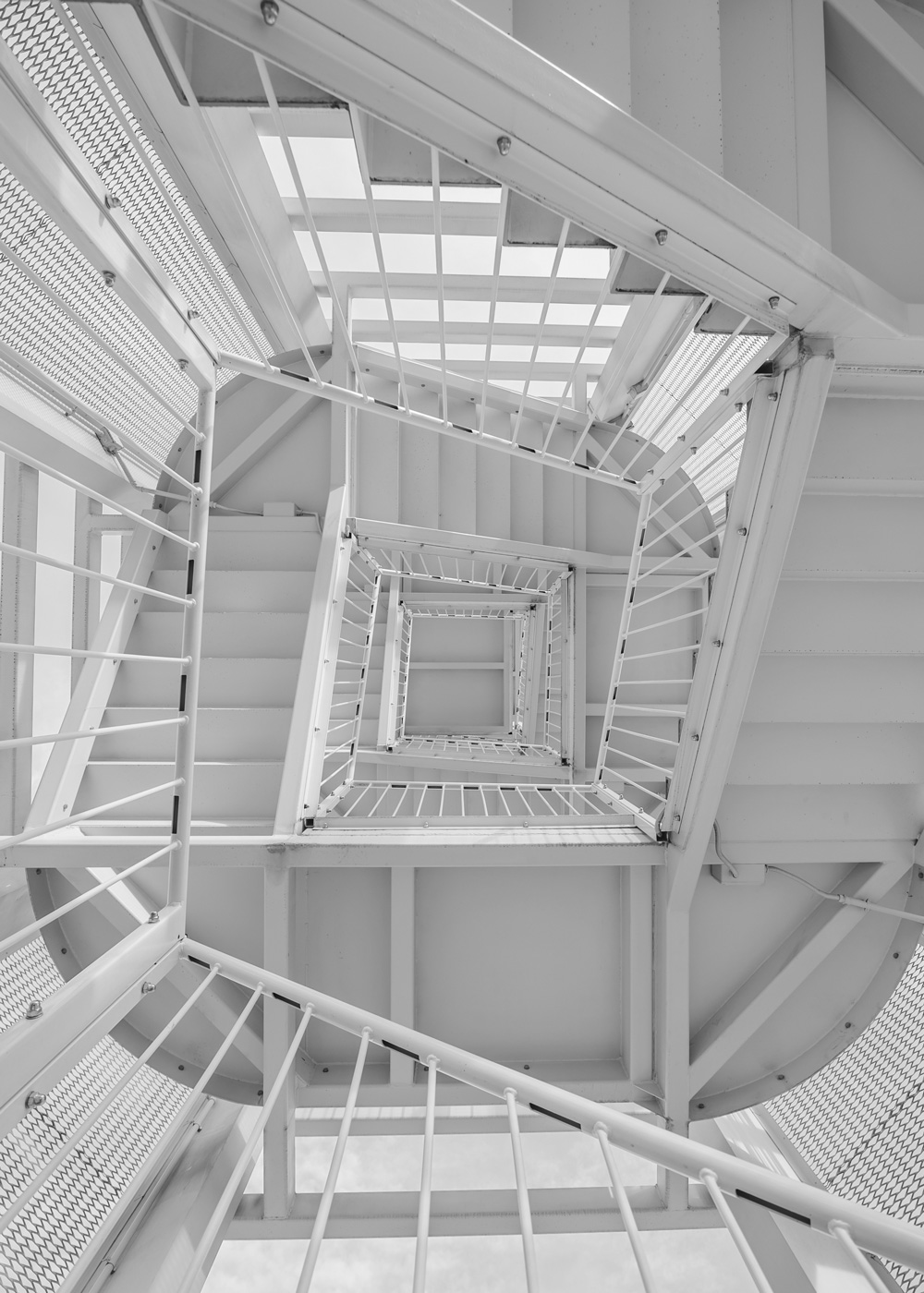 Stairwell from below looking up and seeing endless climbing, spiraling stairs